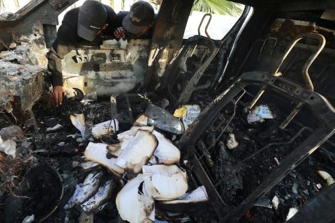 فلسطينيون يتفقدون المركبات المتضررة بشدة بعد الهجمات الإسرائيلية التي استهدفت المسؤولين العاملين في منظمة المساعدة التطوعية الدولية "المطبخ المركزي العالمي" World Central Kitchen (WCK)، في دير البلح، قطاع غزة، في 02 أبريل 2024 : تصوير : عمر اشتيوي