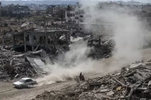 عائلات فلسطينية تعود إلى منازلها مرورا بأنقاض المباني التي دمرها جيش الاحتلال بعد انسحاب القوات الإسرائيلية من أجزاء من خان يونس (الأناضول).webp