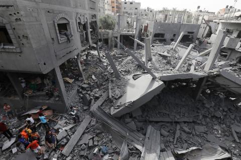فلسطينيون يبحثون عن الجثث والناجين وسط أنقاض المنازل المدمرة في أعقاب غارة جوية إسرائيلية على مخيم المغازي للاجئين، جنوب قطاع غزة