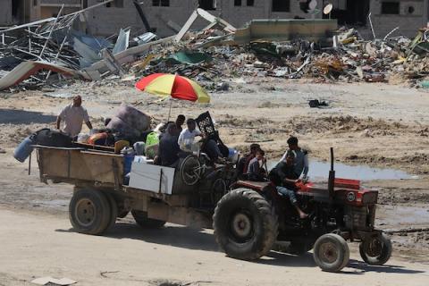 فلسطينيون نازحون داخليًا، يحملون أمتعتهم، ينصبون خيامًا على أنقاض منازلهم بعد أن طلب منهم الجيش الإسرائيلي الإخلاء من مدينة رفح