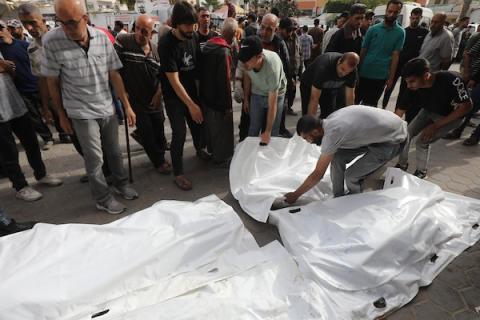 فلسطينيون يؤدون صلاة الجنازة على الجثث التي استشهدت في الغارات الجوية الإسرائيلية قبل مراسم التشييع في مستشفى الأقصى في دير البلح