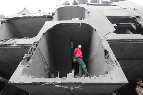 فلسطينيون يبحثون عن الجثث والناجين وسط أنقاض المنازل المدمرة في أعقاب غارة جوية إسرائيلية على مخيم المغازي للاجئين، جنوب قطاع غزة