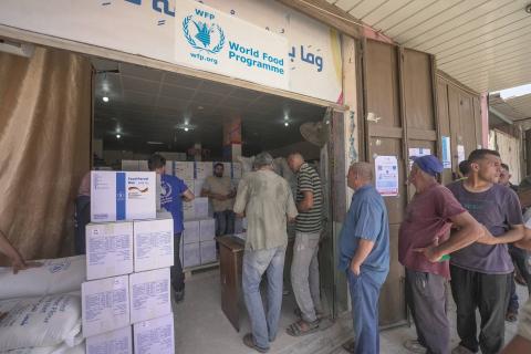 توزيع المساعدات الغذائية في دير البلح بقطاع غزة في إطار برنامج الأغذية العالمي (أرشيفية - رويترز)