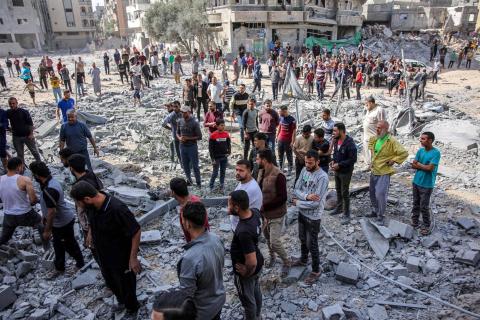 فلسطينيون في موقع غارة إسرائيلية يوم 26 أكتوبر في حي الزرقاء شمال مدينة غزة.jpeg