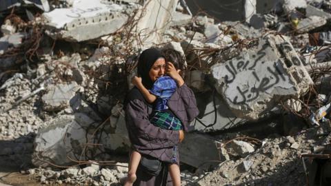 سيدة فلسطينية تحتضن ابنها وسط الدمار في غزة 19 سبتمبر 2024 (أشرف عمرا/الأناضول)