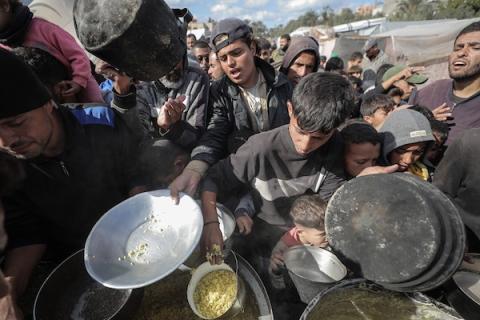 مجموعة من المواطنين امام احد تكيات الطعام في وسط قطاع غزة