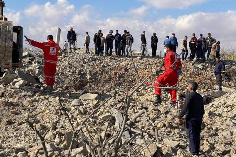 جال إنقاذ وسكان يتجمعون حول أنقاض مبنى دمرته غارة إسرائيلية على قرية يونين في سهل البقاع شرق لبنان.jpeg