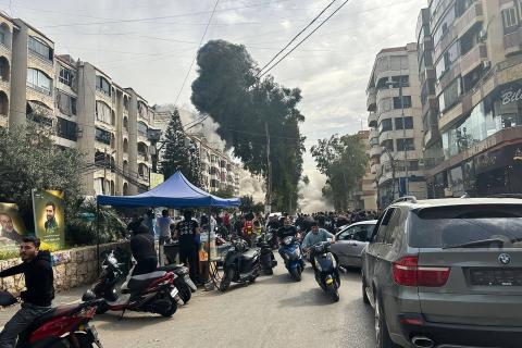 أشخاص يسارعون للاحتماء بينما يتصاعد الدخان من موقع غارة إسرائيلية بالضاحية الجنوبية لبيروت 28 مارس 2025 (أ.ف.ب).jpeg