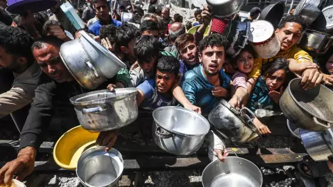 فلسطينيين أمام أحد التكايا شمال قطاع غزة.webp