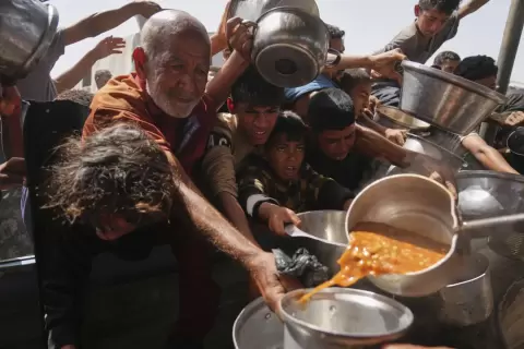 فلسطينيون يتزاحمون للحصول على الطعام من أحد المطابخ الخيرية بقطاع غزة.webp