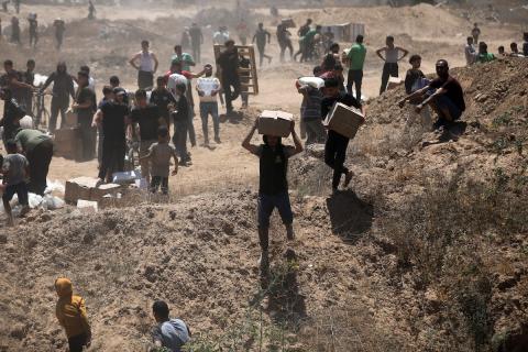 مواطنين يحملون مساعدات في غزة