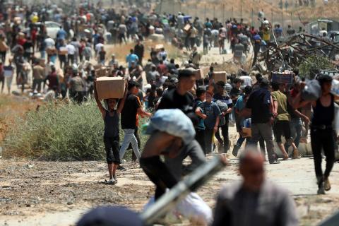 مواطنين يحملون مساعدات في غزة