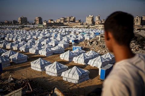 نازحون فلسطينيون يسيرون وسط ملاجئ مؤقتة شمال مدينة غزة