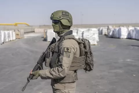 جندي إسرائيلي بجانب طرود مساعدات إنسانية تنتظر استلامها بمعبر كرم أبو سالم في قطاع غزة.webp