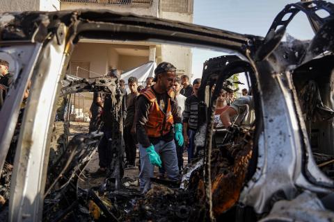 فلسطينيون وفرق الدفاع المدني ينتشلون ضحايا سقطوا في غارات جوية إسرائيلية على سيارة مدنية في منطقة مفترق العباس غرب مدينة غزة، في 22 نوفمبر/تشرين الثاني 2025. تصوير: عمر اشتوي