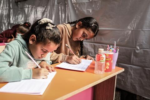 أطفال فلسطينيون نازحون يحضرون درسًا داخل خيمة تُستخدم كفصل دراسي مؤقت في ملجأ بدير البلح (16).jpg