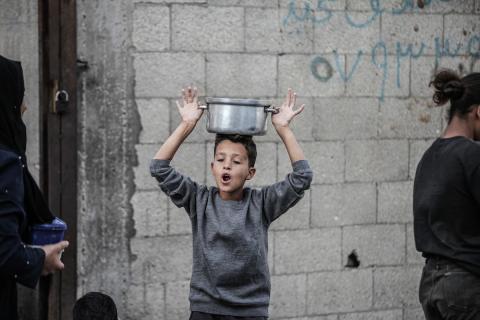 فلسطينيون في مخيم النصيرات وسط قطاع غزة يتلقون وجبات ساخنة من جمعية خيرية للنازحين