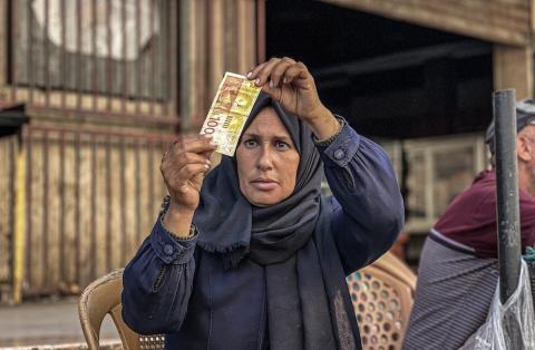 الفلسطينية منال السعيداني تُصلح أوراقًا نقدية قديمة ومهترئة في ظل نفاد العملة الصعبة في قطاع غزة (4).jpg