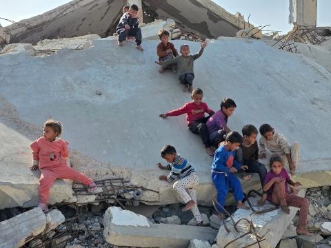 أطفال فلسطينيون يمشون على أسطح منازلهم المدمرة جراء الحرب الإسرائيلية في خان يونس (11).jpg