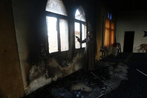 فلسطينيون يتفقدون مسجدًا في بلدة دير استيا بالضفة الغربية بعد أن أضرم فيه مستوطنون إسرائيليون النار، وفقًا لسكان محليين