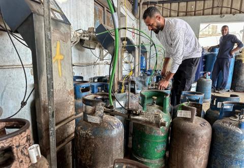 عمال يتعاملون مع أسطوانات الغاز في محطة تعبئة في النصيرات، وسط قطاع غزة، في وقت يعاني فيه القطاع من أزمة حادة في إمدادات الوقود.تصوير: بلال أبو عامر