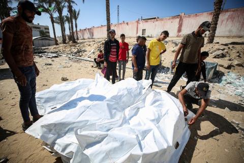 عمال المشرحة يُفرّغون جثث فلسطينيين كانوا محتجزين لدى إسرائيل، بعد نقلها بسيارات الهلال الأحمر وشاحنات التبريد، إلى مستشفى ناصر في خان يونس جنوب قطاع غزة في 16 أكتوبر/تشرين الأول 2025
