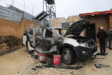 فلسطينيون يقفون في موقع حريق سيارة أشعله مستوطنون إسرائيليون في بلدة حوارة، جنوب نابلس في الضفة الغربية، 28 ديسمبر/كانون الأول 2025. صورة: محمد ناصر