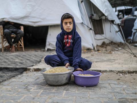 يصطفّ  فلسطينيون لتلقّي الطعام من مطبخ خيري في تجمع للنازحين بمخيم النصيرات للاجئين، وسط قطاع غزة. ١٧ ديسمبر/كانون الأول ٢٠٢٥. تصوير: رمزي أبو عامر / (apa)