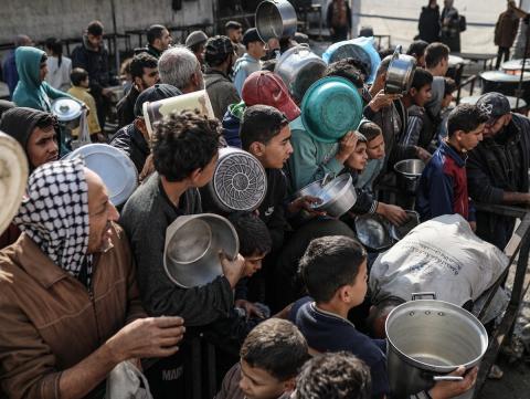 يصطفّ  فلسطينيون لتلقّي الطعام من مطبخ خيري في تجمع للنازحين بمخيم النصيرات للاجئين، وسط قطاع غزة. ١٧ ديسمبر/كانون الأول ٢٠٢٥. تصوير: رمزي أبو عامر / (apa)