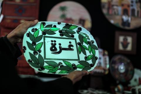 فلسطينيون يحضرون معرضًا  يعرض منتجات يدوية من صنع مجموعة من الحرفيين الصم في مدينة غزة
