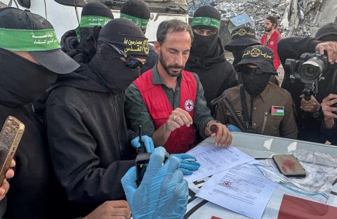 مسلحون من حماس والجهاد الإسلامي في فلسطين يسلمون لأفراد الصليب الأحمر جثة استعادوها من بيت لاهيا قبل تسليمها لإسرائيل لتحديد ما إذا كانت تعود لأحد الرهائن، شمال قطاع غزة، 3 ديسمبر/كانون الأول 2025