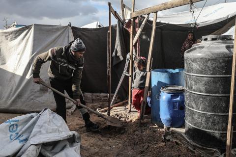 أحمد أبو ليلى أب لخمسة أطفال أصيب في الحرب  يحاول إصلاح خيمته بعد أن تضررت جراء الأمطار الغزيرة والرياح العاتية التي اجتاحت مخيم النصيرات وسط قطاع غزة، 28 ديسمبر/كانون الأول 2025.تصوير: معز صالحي