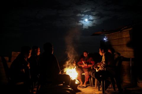 يعيش الفلسطينيون حياتهم اليومية ليلاً في خيام نصبت فوق أنقاض المباني المدمرة في حي الشيخ رضوان وسط مدينة غزة، 5 ديسمبر/كانون الأول 2025.تصوير: عمر أشتوي