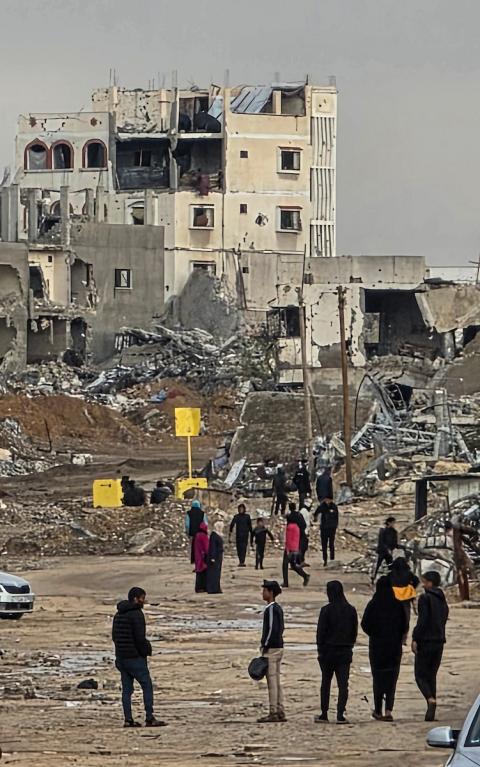 عائلة فلسطينية تحتمي من برد الشتاء القارس في خيمة نصبتها فوق منزلها المدمر قرب الخط الأصفر في خان يونس، جنوب قطاع غزة، ١٧ ديسمبر/كانون الأول ٢٠٢٥. تصوير: طارق محمد/وكالة الأنباء الفلسطينية (APA )