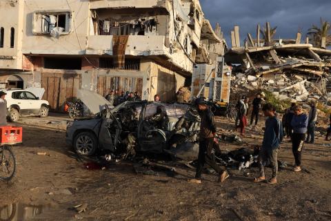 فلسطينيون يتفقدون موقع غارة إسرائيلية استهدفت سيارة على شارع الرشيد غرب مدينة غزة، 13 ديسمبر/كانون الأول 2025. صور: عمر أشتوي