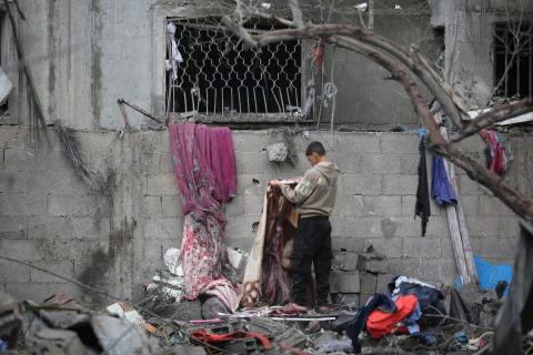 يبحث فلسطينيون عن ممتلكاتهم بين الأنقاض بعد أن دمرت غارات جوية إسرائيلية مبنى في مخيم البريج للاجئين وسط قطاع غزة. دمر الهجوم المبنى بالكامل وألحق أضرارًا بالمنشآت المحيطة به، 9 يناير/كانون الثاني 2026. صورة: معز صالحي