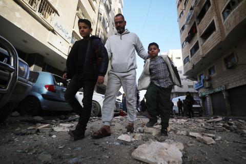 فلسطينيون يمرون أمام مبنى سكني تضرر جراء غارة عسكرية إسرائيلية أسفرت عن سقوط عدد من الضحايا في مدينة غزة، السبت 31 يناير/كانون الثاني 2026. صورة: عمر أشتوي
