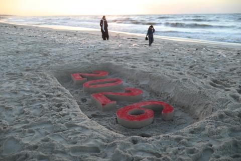 فلسطينيون يودعون عام 2025 بكتابة 2026 على رمال شاطئ غزة، 31 ديسمبركانون الأول 2025. صورة عمر أشتوي