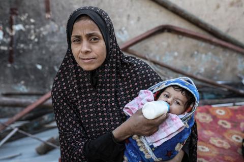 فلسطينيون يتفقدون منزلاً (تضرر سابقاً جراء غارة جوية إسرائيلية) انهار على سكانه، ما أسفر عن وفاة رجل ونجله الصغير في مخيم المغازي للاجئين وسط قطاع غزة، 5 يناير/كانون الثاني 2026. صورة: رمزي أبو عامر