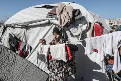 تجلس الفلسطينية سحر محمود التلولي، 43 عامًا، داخل خيمة في مخيم البريج للاجئين وسط قطاع غزة، بعد أن أصيبت يدها اليسرى وتشوهت جراء القصف الإسرائيلي، وذلك بعد نزوحها المتكرر من شمال القطاع.تصوير: معز صالحي