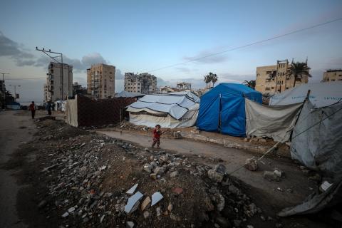 يسير فلسطينيون في شوارع مدينة غزة، وسط الأنقاض والدمار الذي خلفه الصراع الدائر، في 10 يناير/كانون الثاني 2026، بينما تستمر الحياة اليومية في ظل ظروف صعبة. صورة: عمر أشتوي