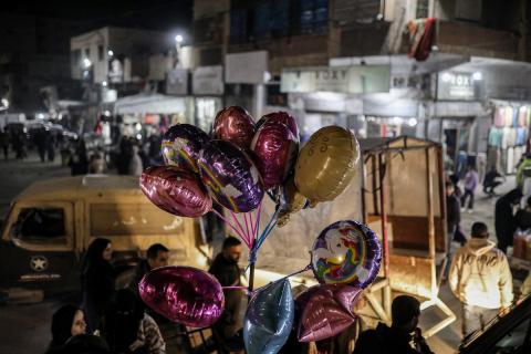 يسير فلسطينيون في سوق شارع عمر المختار بحي الرمال في مدينة غزة في ليل 31 ديسمبر/كانون الأول 2025، آخر أيام عام 2025، حيث يشهد السوق، الذي أصبح ملاذاً للسكان بعد الدمار الإسرائيلي، ازدحاماً شديداً طوال اليوم. صورة: عمر أشتوي