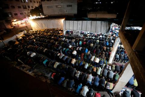 فلسطينيون يؤدون صلاة التراويح في أول ليلة من شهر رمضان على أنقاض مسجد الكنز المدمر في مدينة غزة، في 17 فبراير/شباط 2026. وكان مفتي القدس والأراضي الفلسطينية قد أعلن أن يوم الأربعاء 18 فبراير/شباط 2026 هو أول أيام رمضان. (صورة: عمر أشتوي)