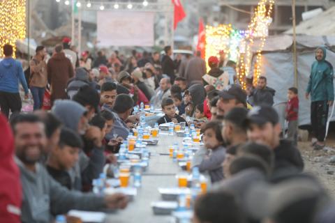 يتجمع فلسطينيون نازحون لتناول وجبة الإفطار وسط أنقاض المباني المدمرة في مدينة غزة، خلال شهر رمضان المبارك، في 25 فبراير/شباط 2026. صورة: عمر أشتوي