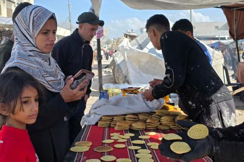 بائعٌ يُعدّ حلوى القطايف الشهيرة بالطرق التقليدية احتفالاً بشهر رمضان المبارك. ورغم الظروف المعيشية الصعبة، يواصل السكان شراء هذه الحلوى التقليدية. خان يونس، جنوب قطاع غزة، ٢٢ فبراير ٢٠٢٦. تصوير: طارق محمد