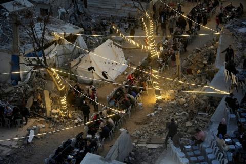 يتجمع الفلسطينيون بين المنازل المدمرة لتناول وجبة الإفطار معًا خلال شهر رمضان المبارك في شمال قطاع غزة، 22 فبراير/شباط 2026. صورة: عمر أشتوي