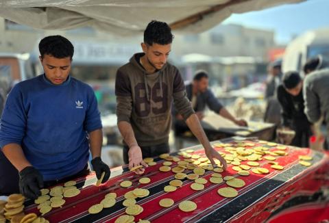 بائعٌ يُعدّ حلوى القطايف الشهيرة بالطرق التقليدية احتفالاً بشهر رمضان المبارك. ورغم الظروف المعيشية الصعبة، يواصل السكان شراء هذه الحلوى التقليدية. خان يونس، جنوب قطاع غزة، ٢٢ فبراير ٢٠٢٦. تصوير: طارق محمد
