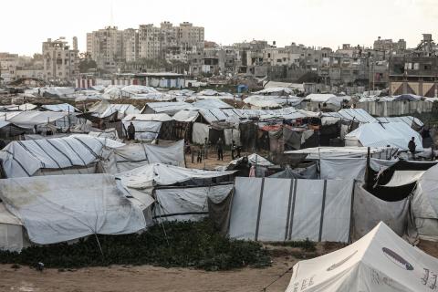 عائلة فلسطينية نازحة تتناول فطورها خلال شهر رمضان داخل خيمة متداعية في مخيم النصيرات للاجئين وسط قطاع غزة. تواجه العائلات النازحة ظروفًا معيشية قاسية نتيجة الحرب، مع انعدام الدخل ونقص حاد في المساعدات الإنسانية، 26 فبراير/شباط 2026. تصوير: معز صالحي