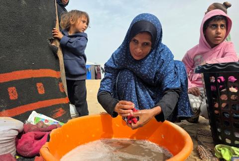 هالة عوض (48 عاما) كفيفة فقدت زوجها في هجوم إسرائيلي، تعيش مع أطفالها السبعة في خيمة مؤقتة غرب خان يونس، وتعيلهم بمفردها رغم إعاقتها البصرية. تصوير: طارق محمد