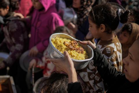فلسطينيون بينهم أطفال ونساء يتلقون مساعدات غذائية وزعتها منظمات خيرية في أحد مراكز الإيواء بمدينة غزة، وسط أزمة غذائية مستمرة ناجمة عن محدودية المساعدات الإنسانية والظروف الإنسانية المتردية التي يواجهها النازحون، ١٢ فبراير/شباط ٢٠٢٦. تصوير: عمر أشتوي